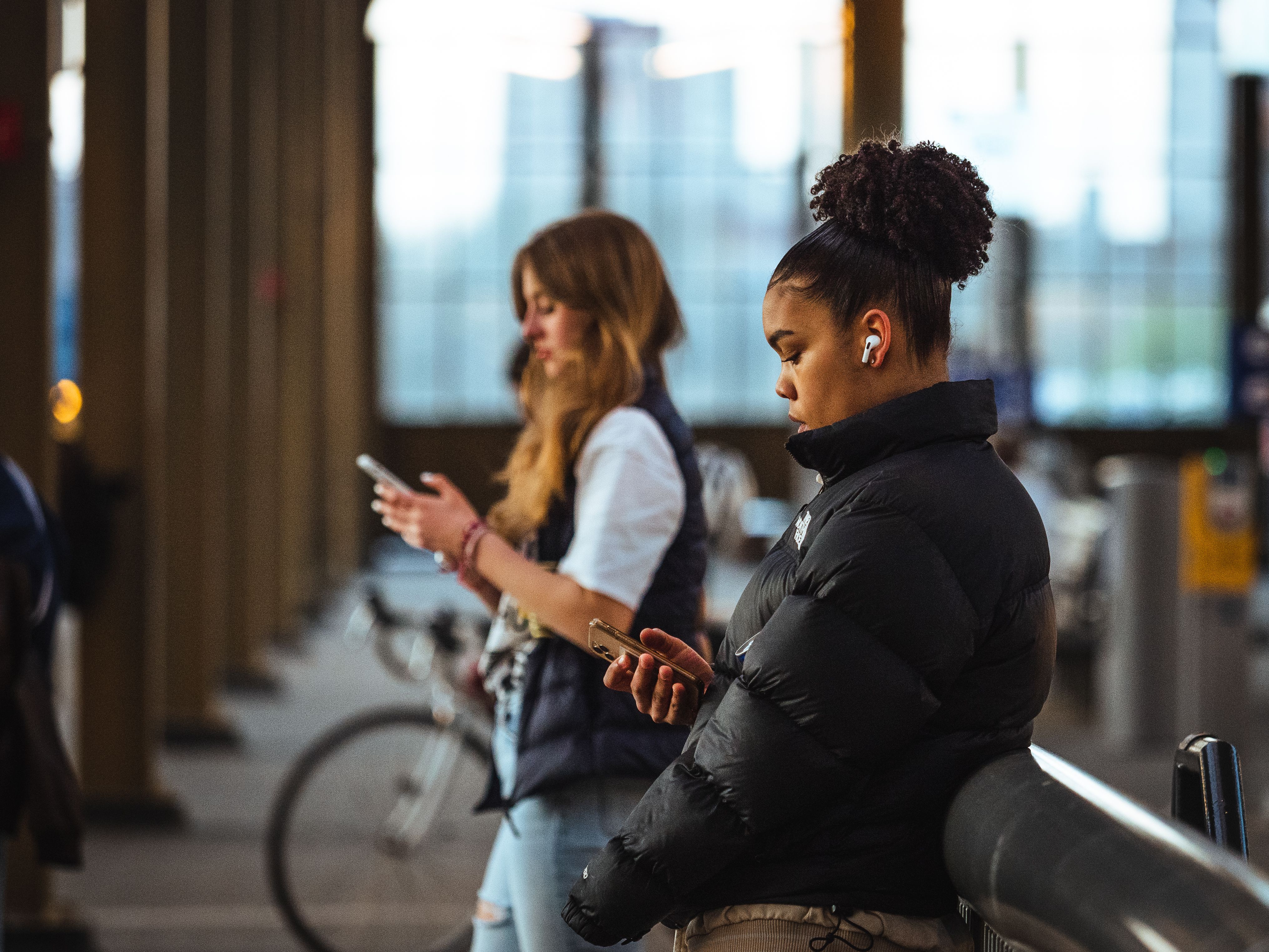 person using AI translation earbuds in a busy city