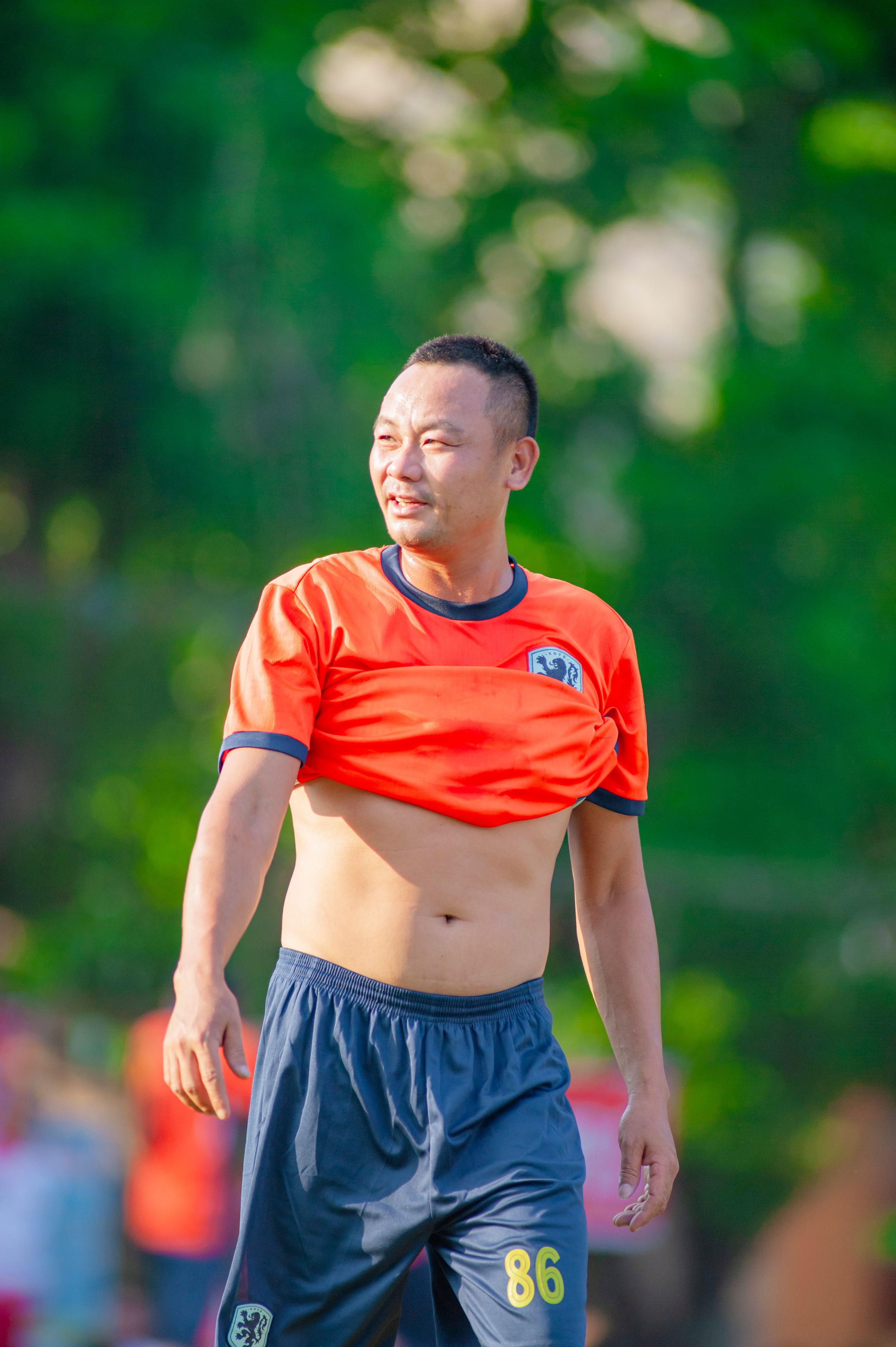 An adult man participating in a casual outdoor football match in Hà Nội, Vietnam.