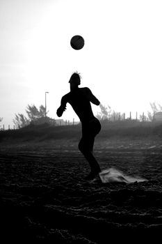 Dramatic silhouette of a soccer player jumping in Rio de Janeiro, capturing motion and athleticism.