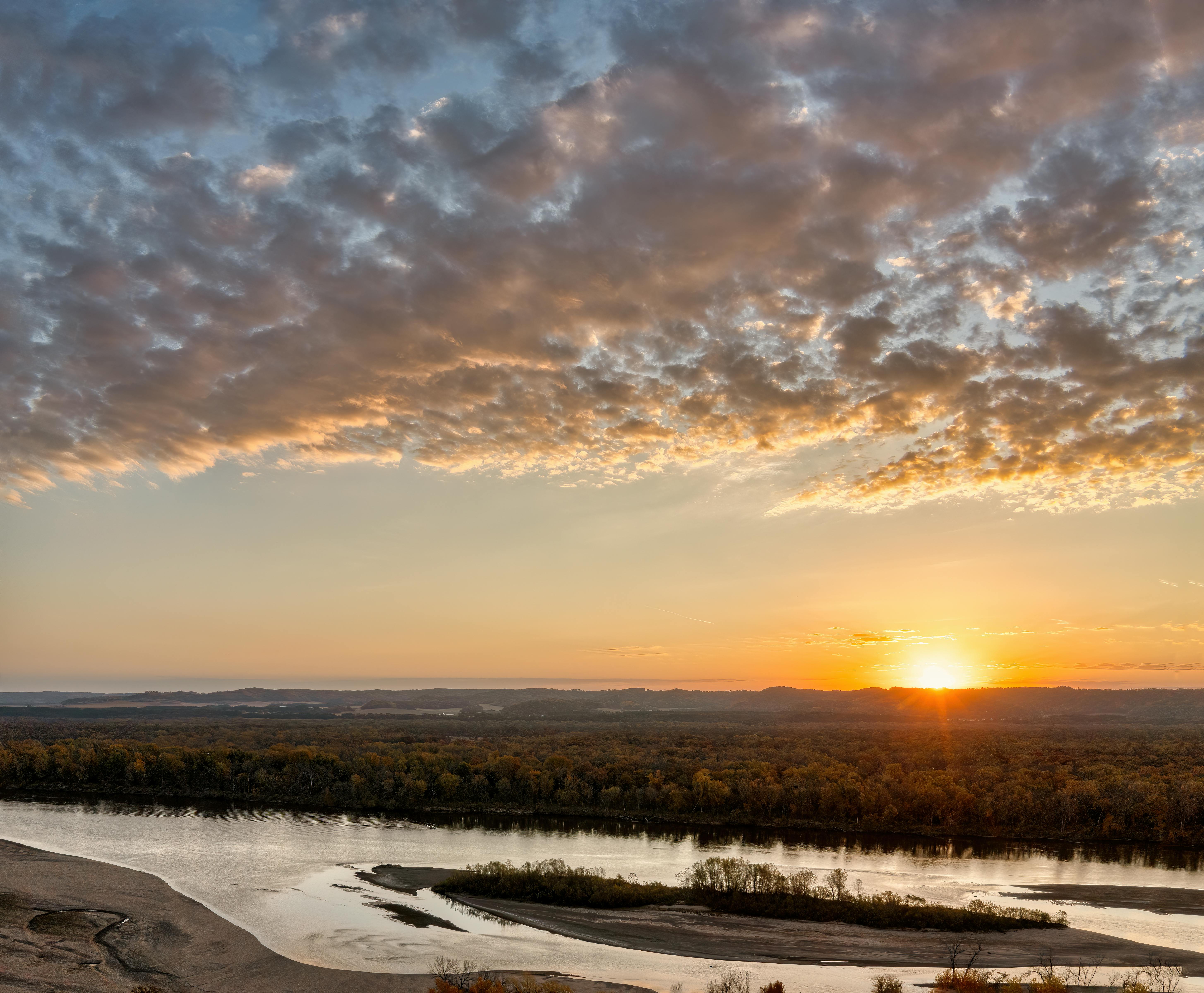A beautiful autumn sunrise over the Mississippi River with vibrant skies.
