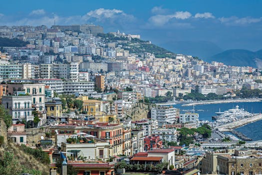 A breathtaking view of the colorful buildings and coastline of Naples, Italy, showcasing the vibrant city life and stunning sea.
