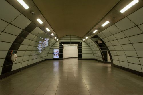 Free Empty underground subway hallway with curved walls and overhead lights. Stock Photo