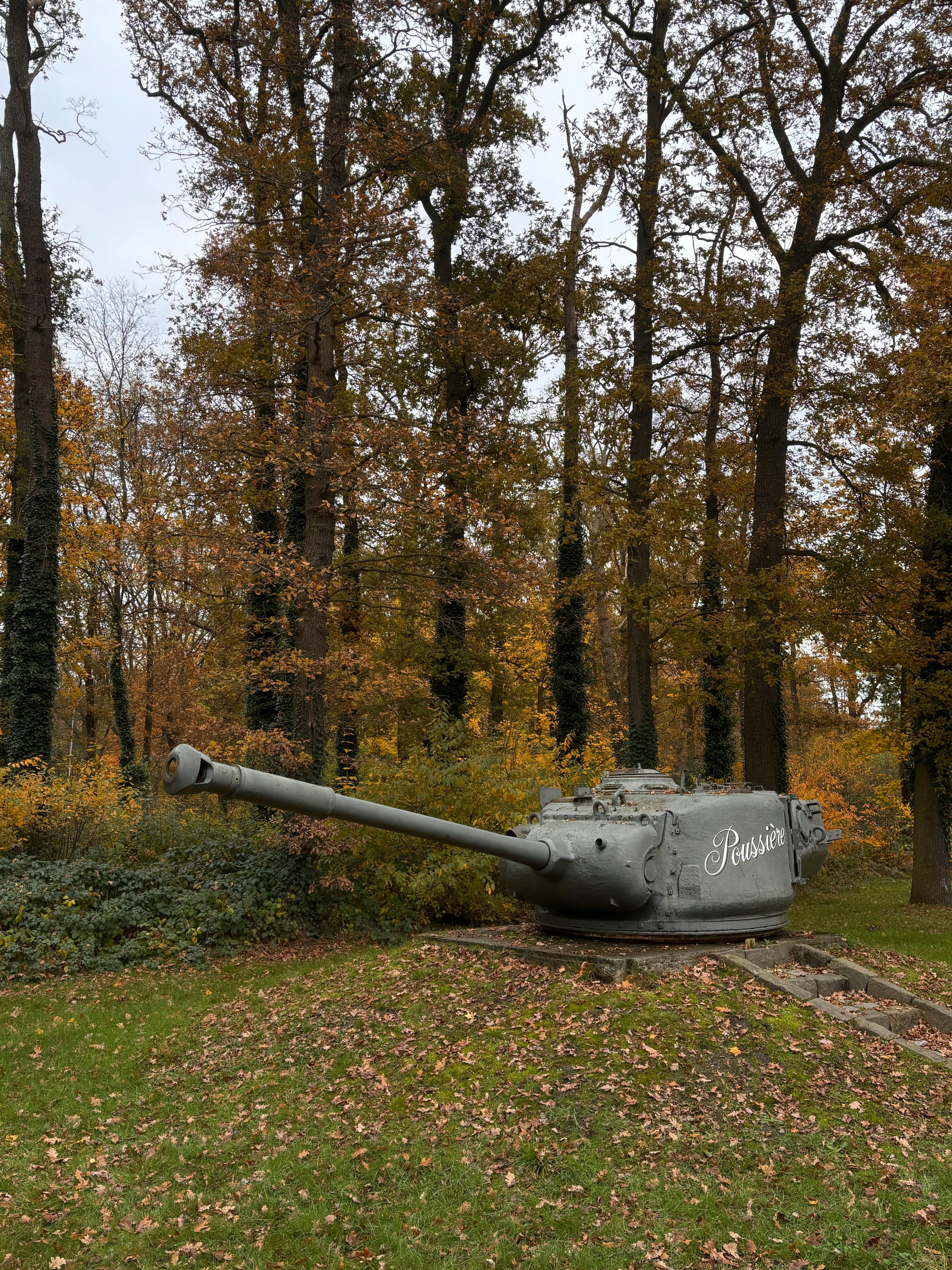Tank turret sits in an autumn forest in Leopoldsburg, Belgium.
