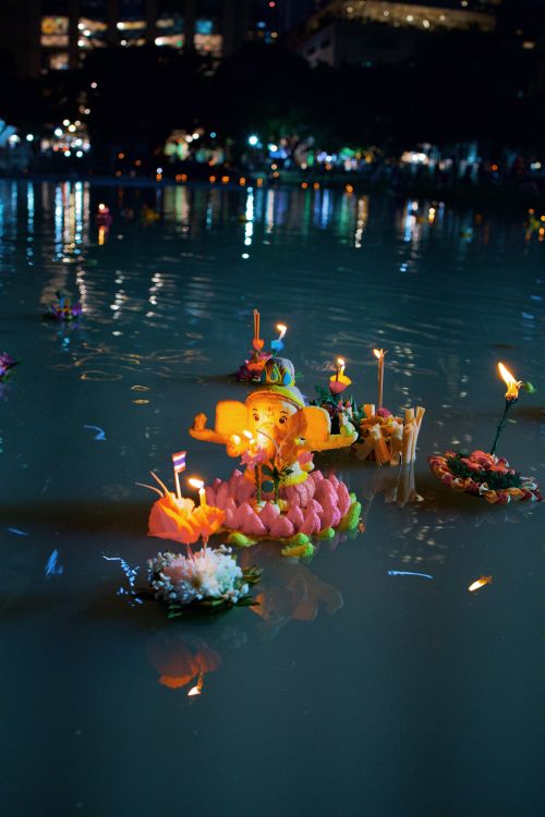 Free Floating krathongs with candles illuminate the water during the Loy Krathong festival in Bangkok, Thailand. Stock Photo