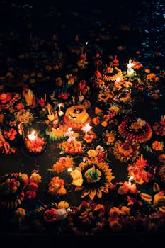 Vibrant floating flower arrangements and candles during Loy Krathong festival in Bangkok, Thailand.
