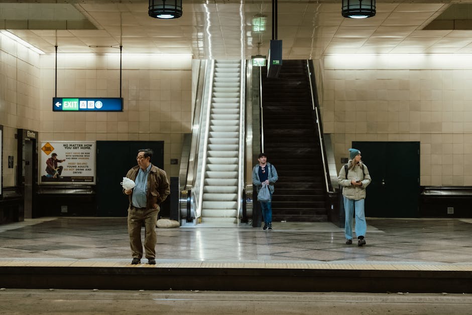 Three people in an underground Seattle station during the day.