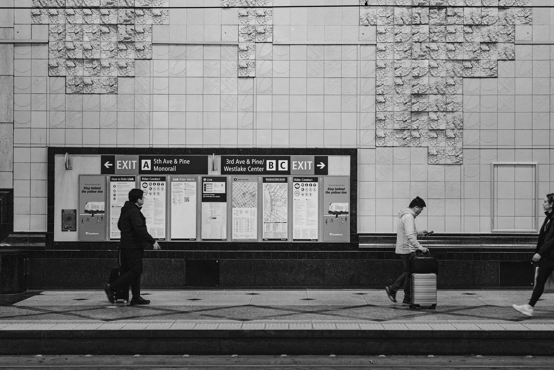 Black and white scene of people at a Seattle train station, capturing urban transit life.