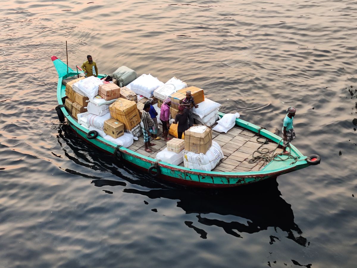 Cargo boat loaded with parcels and sacks on a river in Dhaka