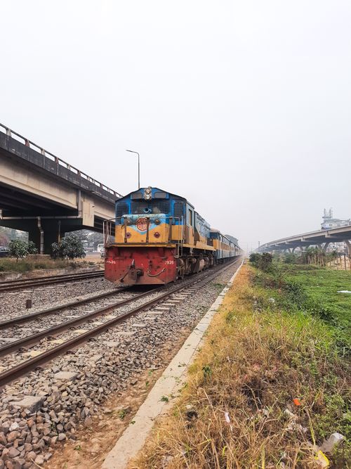 Free A train travels on a railway track under a bridge in Dhaka, Bangladesh. Stock Photo