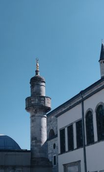 A beautiful mosque with a detailed minaret against a clear blue sky.