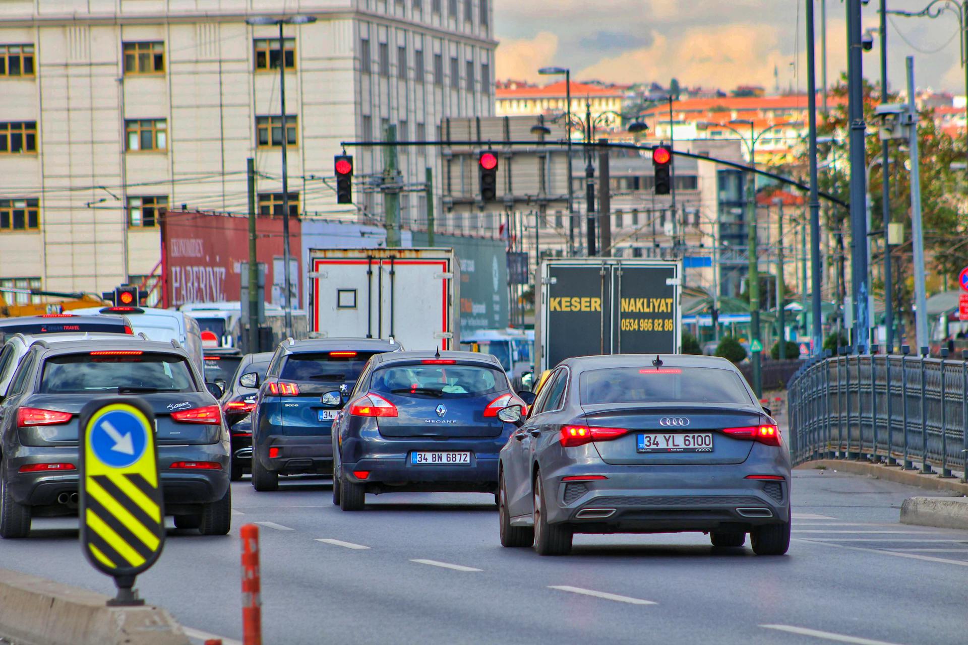 Heavy urban traffic jam with diverse vehicles and street signs.