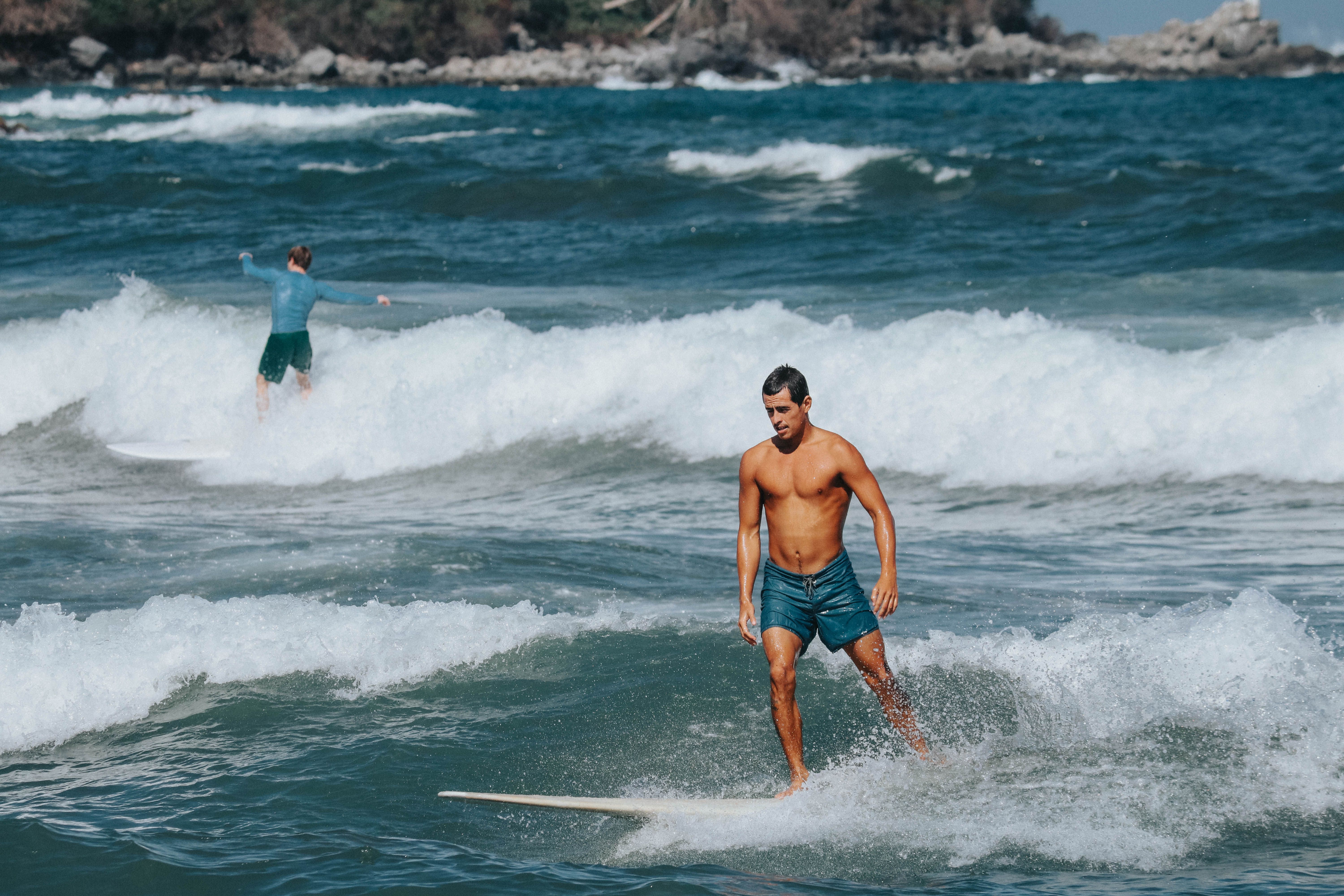 Two Surfers Riding Waves on a Sunny Day · Free Stock Photo
