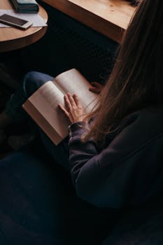 一名年轻女子在窗边舒适的室内环境中看书