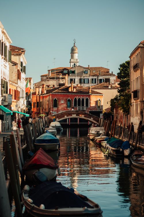 Free Explore a serene canal in Venice, Italy, surrounded by charming architecture and moored boats. Stock Photo