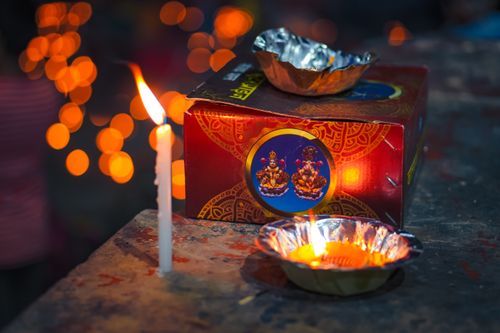 Free A vibrant night scene featuring a festive candle and diya lights in a decorative setting. Stock Photo