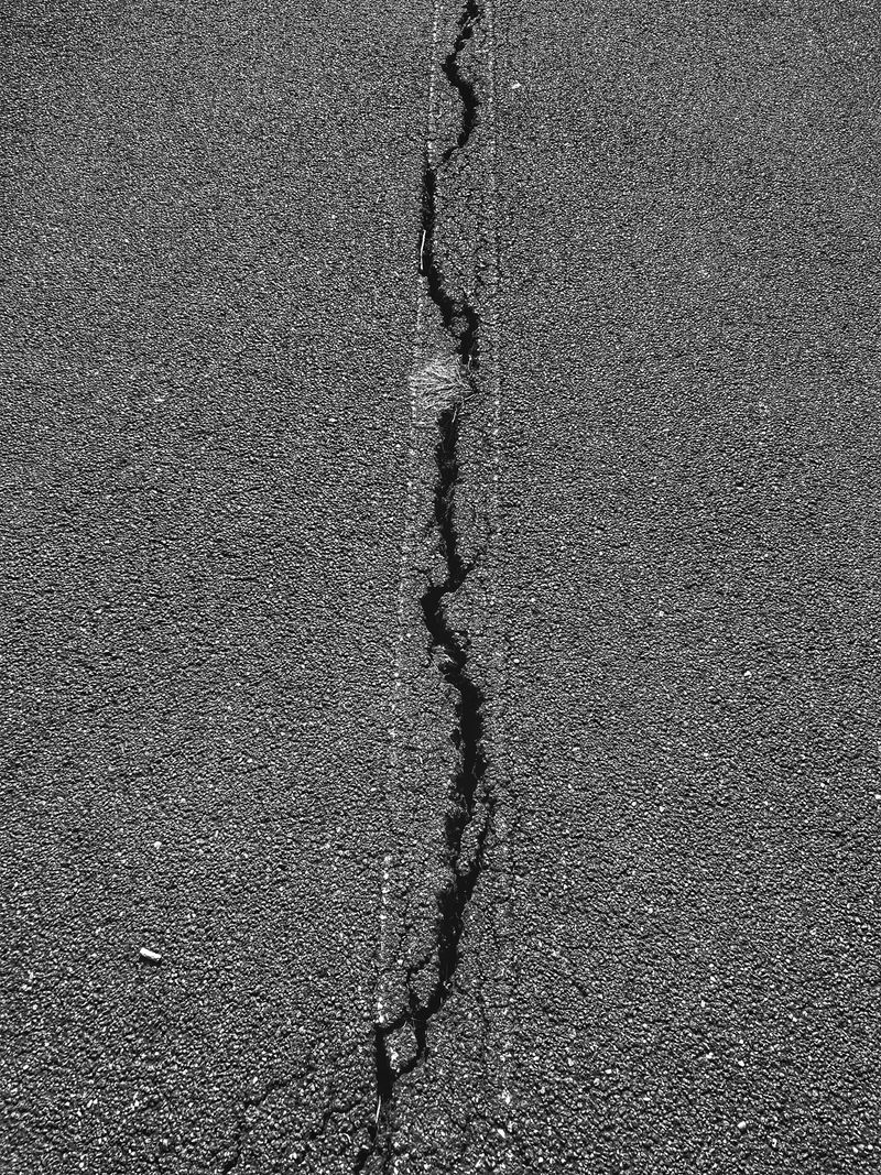 Close-up of crack in asphalt pavement