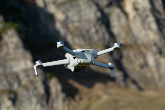 A drone flies in front of rocky mountains in Walenstadt, Switzerland.