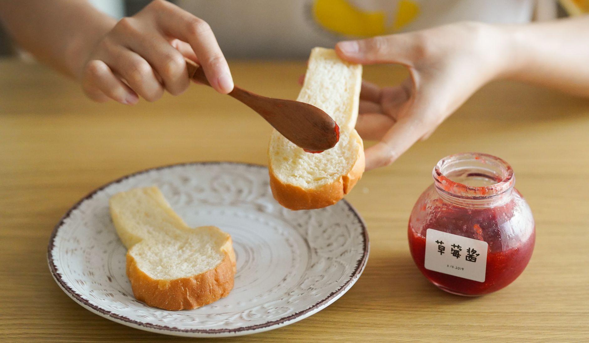 Fresh strawberries beside an open jar of strawberry jam