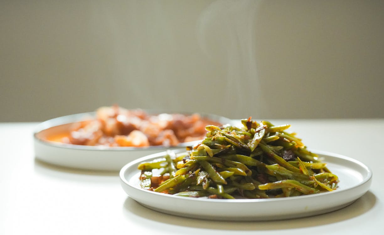 Free Steaming Green Beans and Stew on White Plates Stock Photo