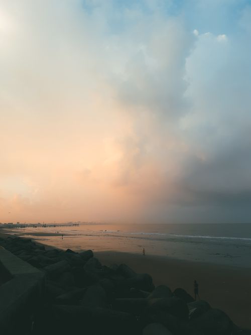 Free A tranquil beach scene at dawn with a vast sky and soft colors, evoking peace and tranquility. Stock Photo