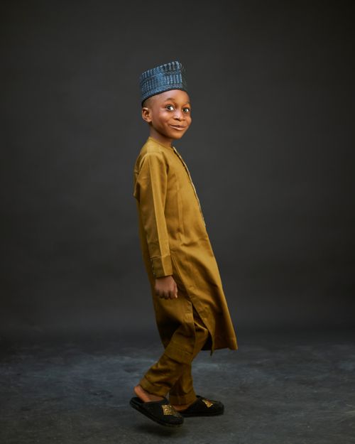 Free Young boy smiling in traditional attire, studio portrait. Stock Photo