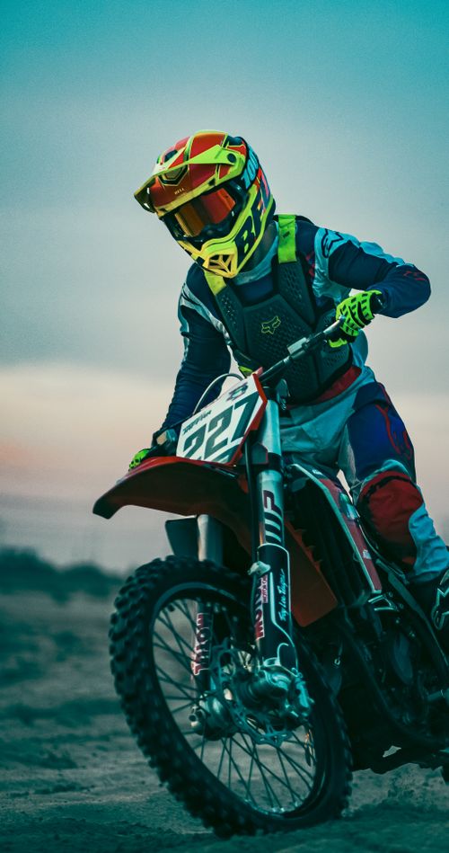 Free Close-up of a motorcyclist riding off-road at twilight on a dirt bike. Stock Photo