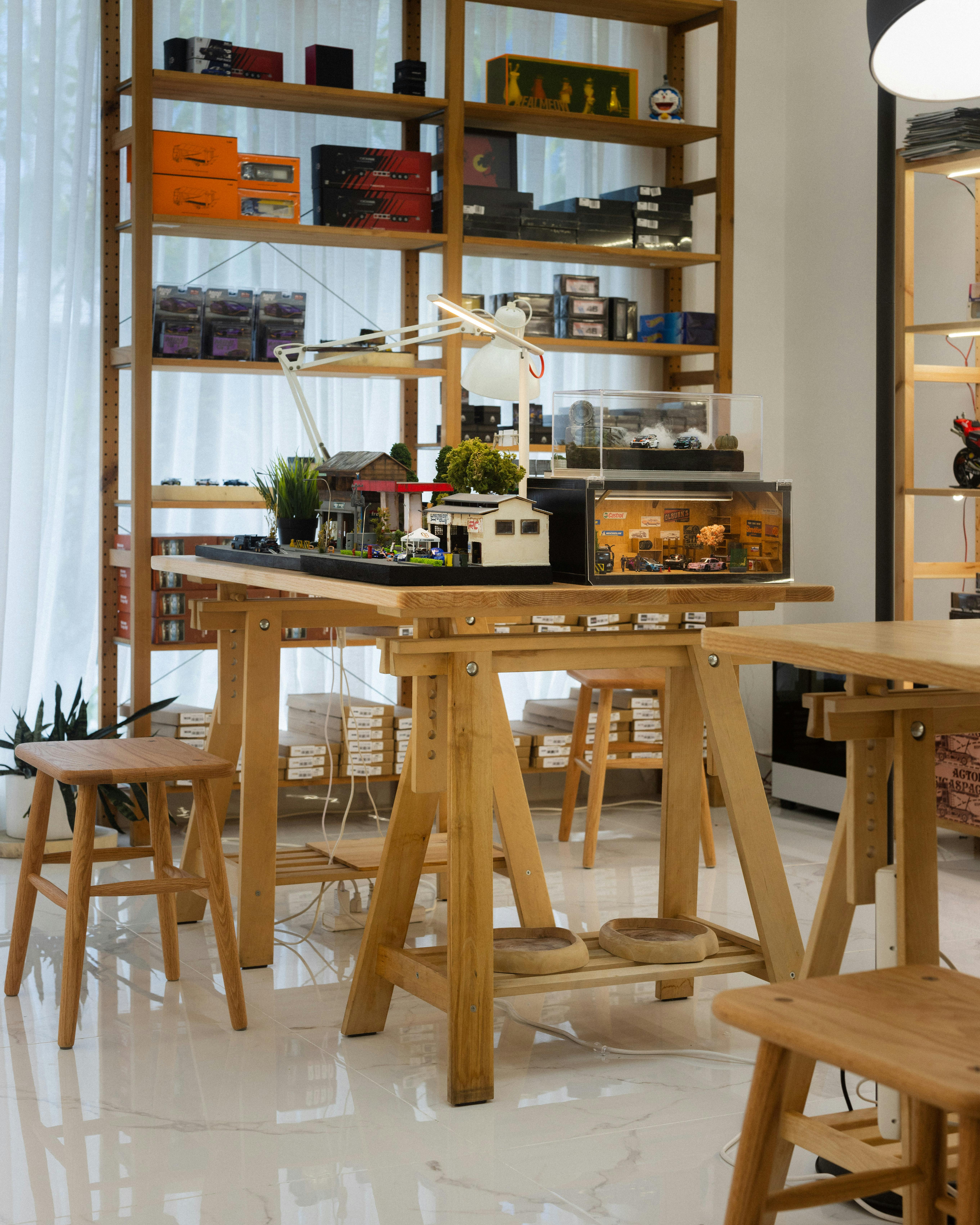 bezplatná Dobře osvětlený kambodžský obchod s dřevěným nábytkem a řadou vystavených modelů aut. Základová fotografie