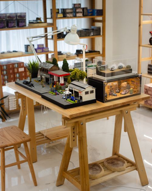 Free A well-organized display of miniature model cars on a wooden table in a Cambodian store setting. Stock Photo