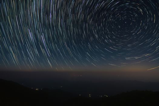 A mesmerizing long exposure shot capturing circular star trails in a clear night sky.