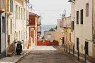 在地中海小镇上，一条安静的小巷在晴朗的天空下通向大海