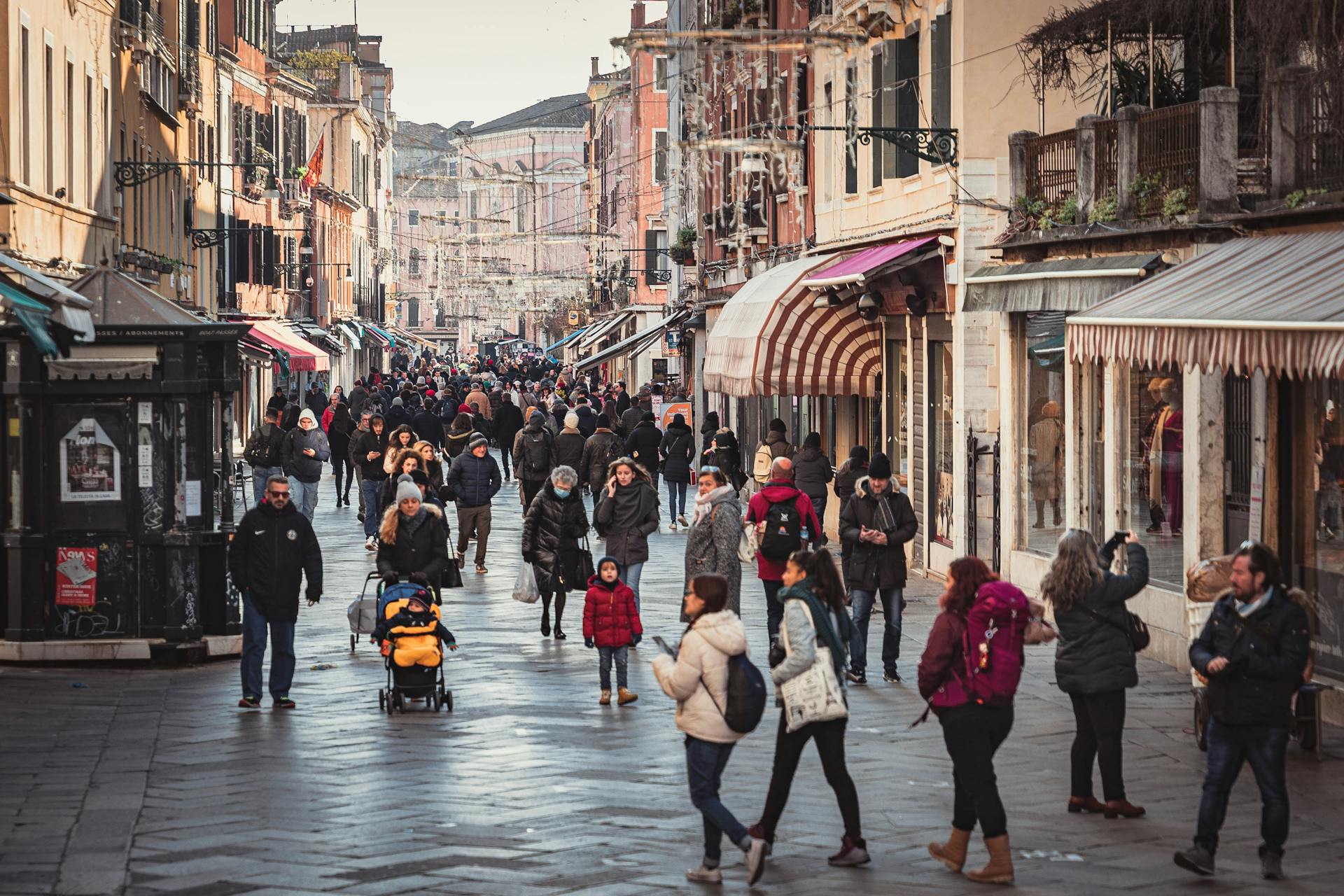 Crowded street in a European city filled with winter shoppers in a vibrant outdoor market area.