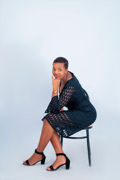 Free Elegant portrait of a woman sitting on a chair, stylish black dress. Stock Photo