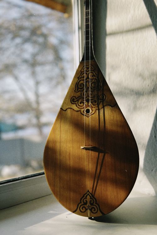 Free A beautifully crafted Kazakh dombra displayed by a window, capturing natural light. Stock Photo