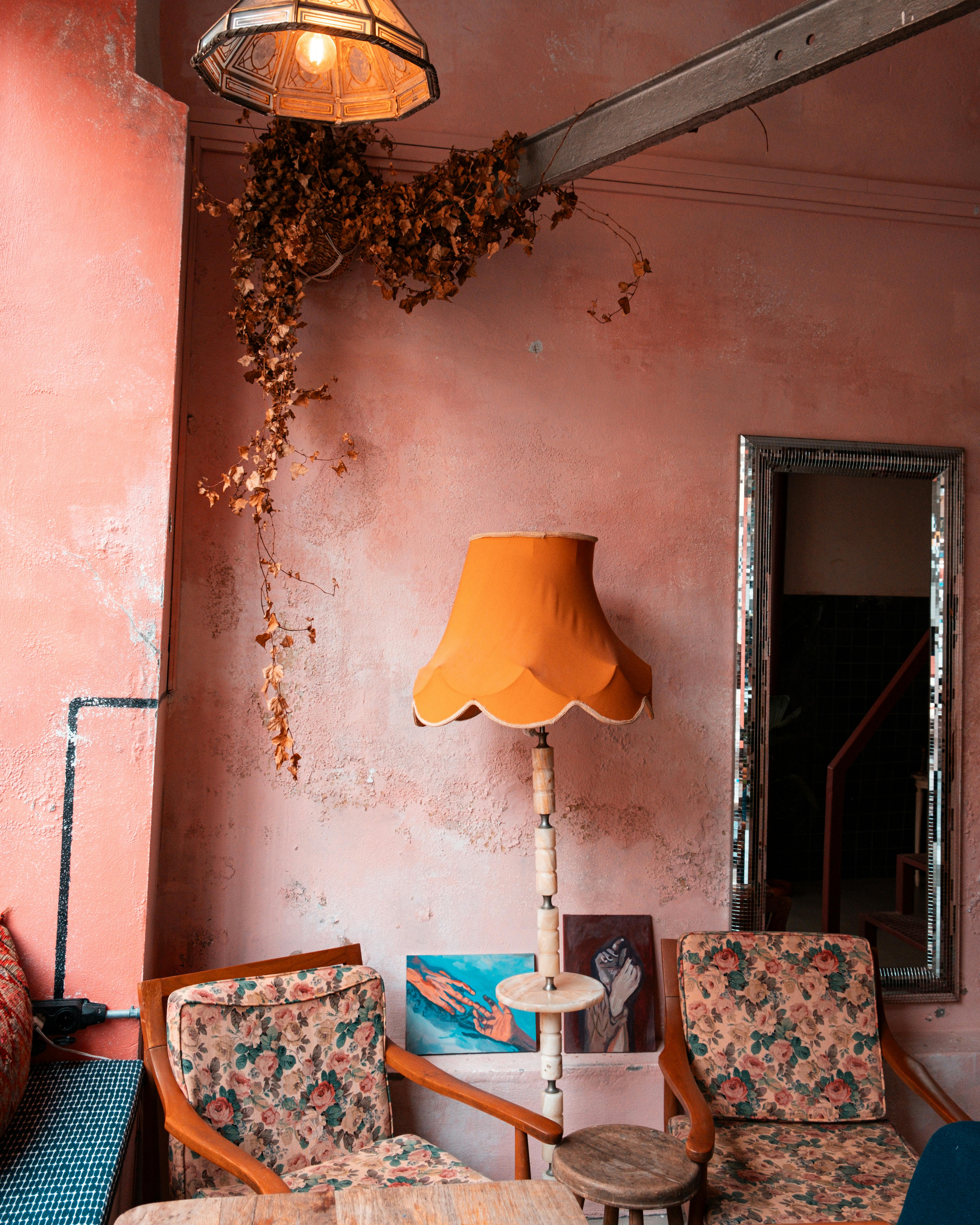 Warm vintage living room with floral chairs and an orange lamp