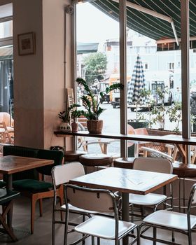 Empty cafe interior showing tables and chairs with view outside.