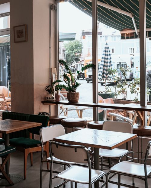 Free Empty cafe interior showing tables and chairs with view outside. Stock Photo