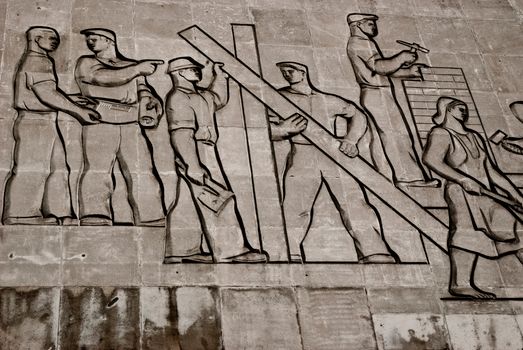 A detailed view of a Soviet-era relief sculpture depicting workers in Budapest, Hungary.