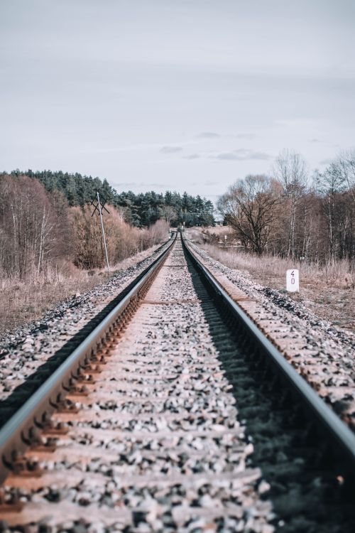 Free A captivating view of a railroad track stretching through serene countryside, reflecting tranquility. Stock Photo