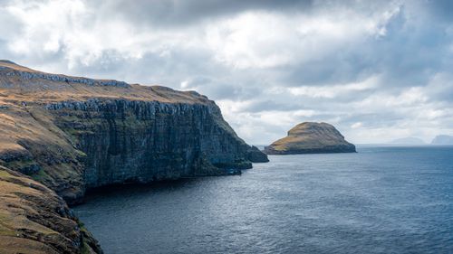 Free Breathtaking view of mossy sea cliffs under a dramatic sky in the Faroe Islands. Stock Photo