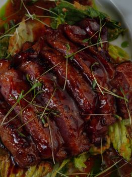 Mouth-watering glazed roast pork slices served with fresh microgreens.