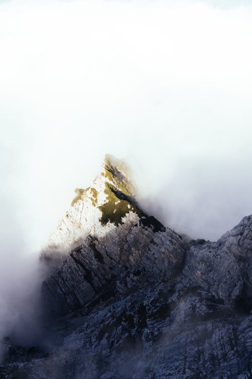 Toma Aérea De Densas Nubes Arrastrándose Sobre El Pico De La Montaña