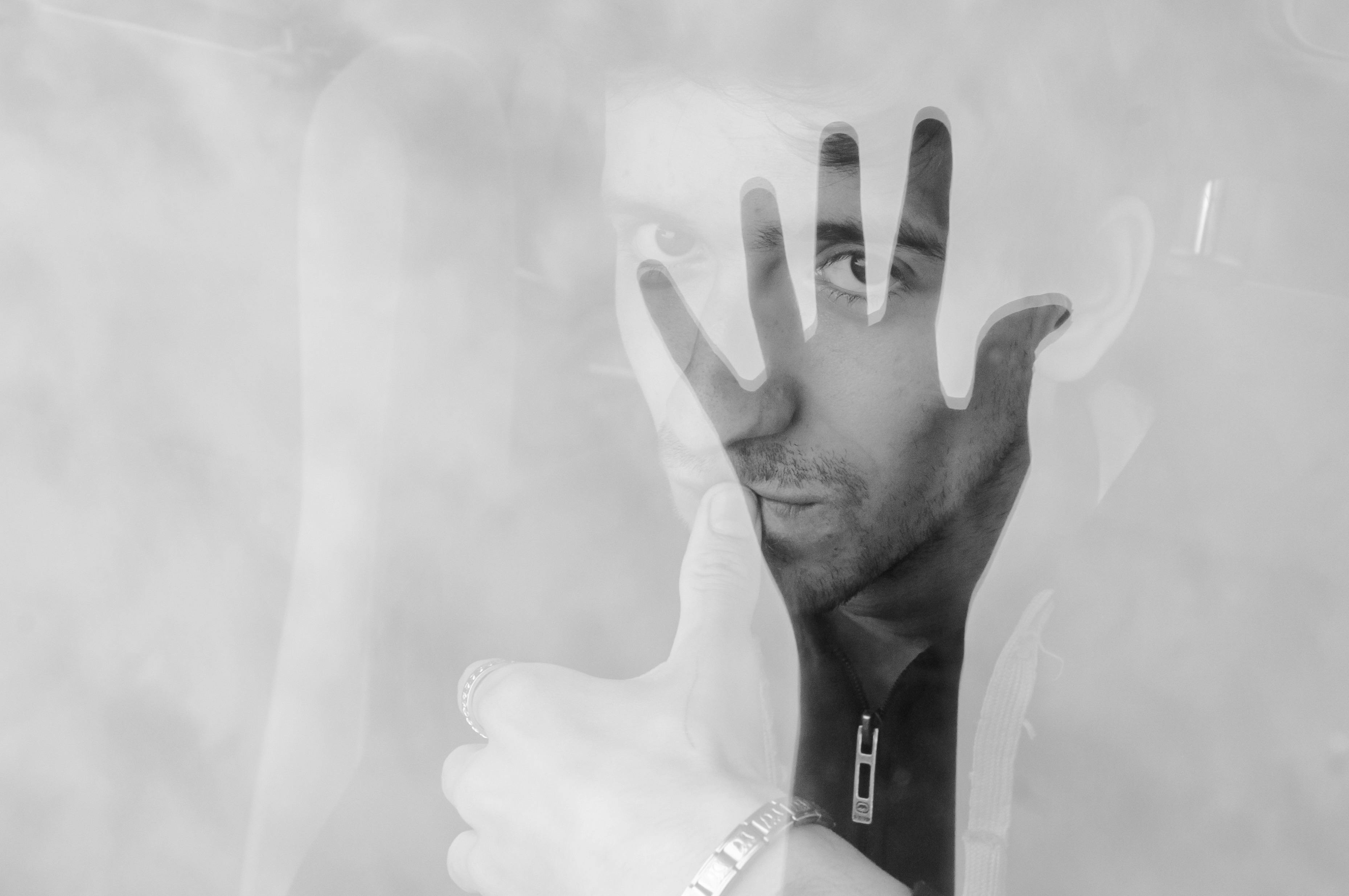 De franc Retrat abstracte en blanc i negre amb superposició de mà, que representa el misteri i la introspecció. Foto d'estoc