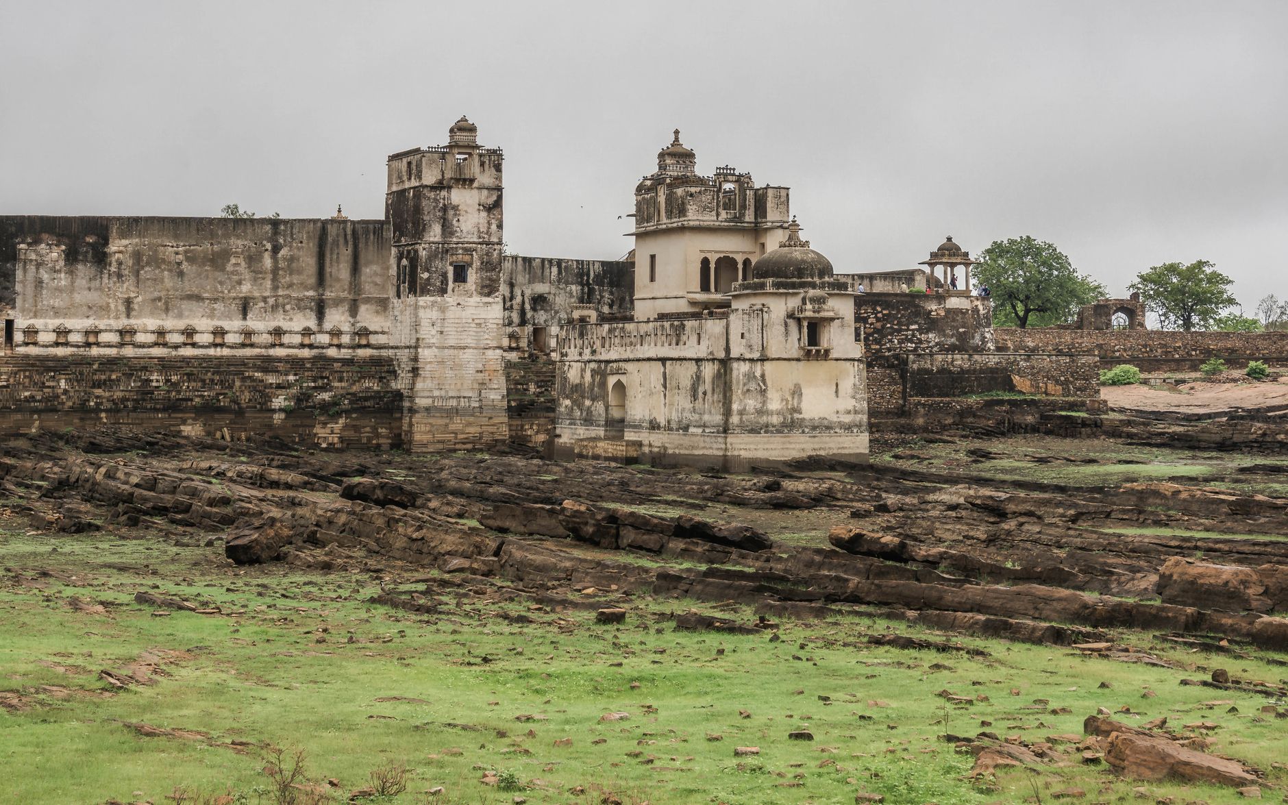 Historic Chittorgarh Fort in Rajasthan, India, with overcast sky and lush surroundings.