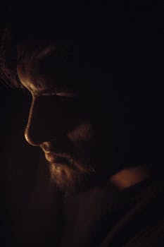 Artistic portrait with dramatic shadow play, capturing the moody expression of a man.