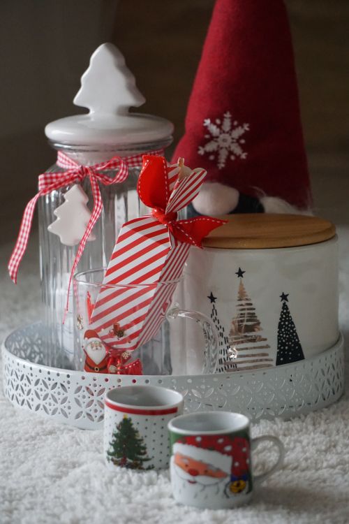 Free Cozy Christmas setup with decorative jars and festive mugs, perfect for holiday atmosphere. Stock Photo