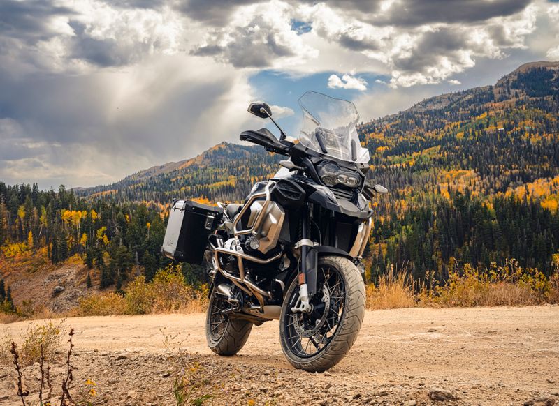 Powerful adventure motorcycle parked on a mountain road with autumn foliage