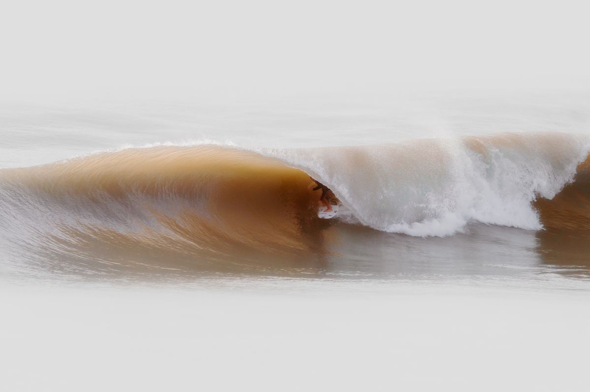 Clean barreling wave on the Miyazaki Pacific coast under pale sky — year-round surfing conditions