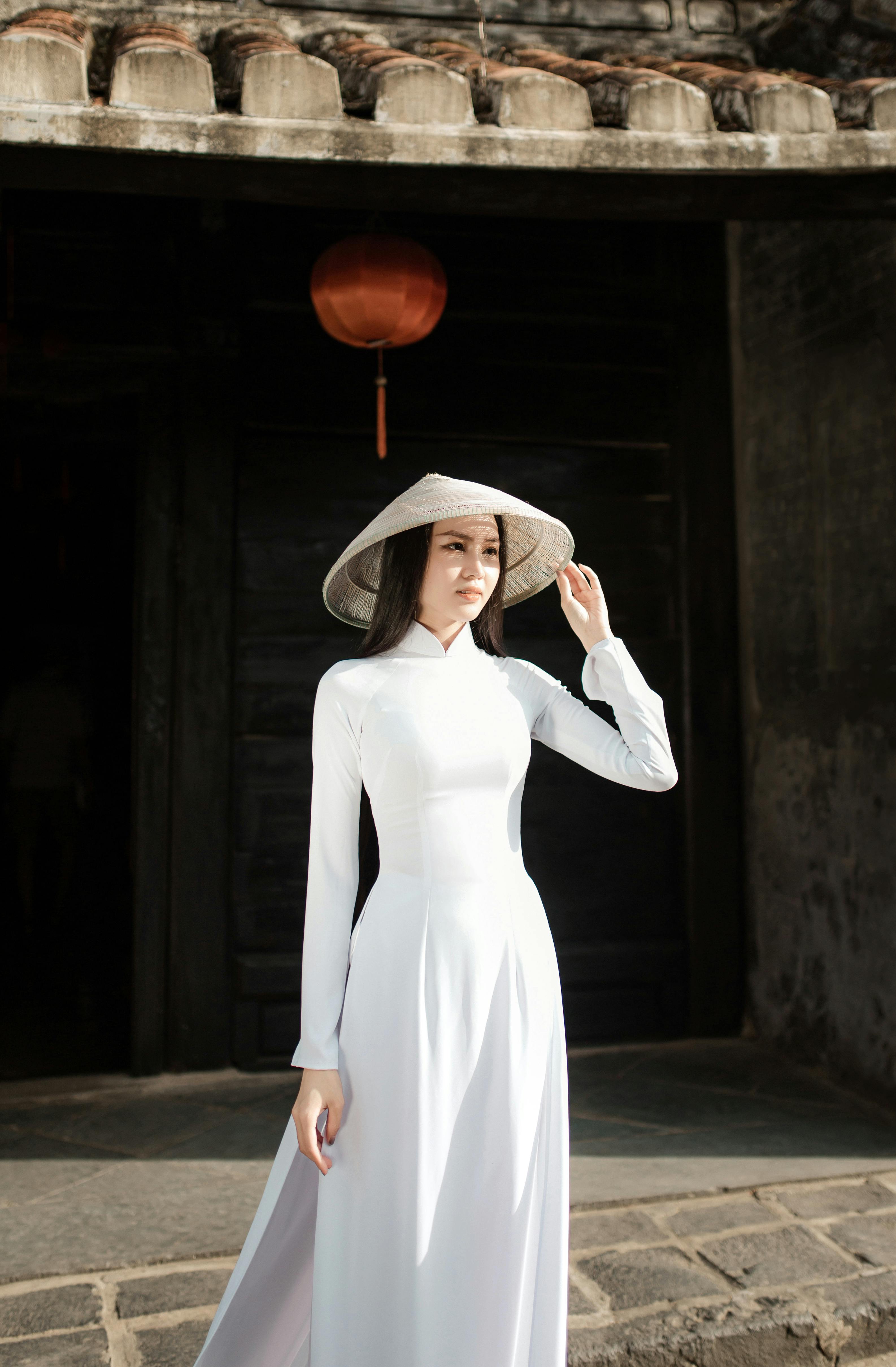 Elegant Vietnamese woman in traditional Ao Dai standing in historic Hoi An, Vietnam.