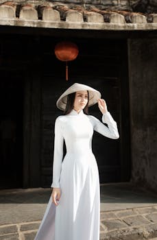 Elegant Vietnamese woman in traditional Ao Dai standing in historic Hoi An, Vietnam.