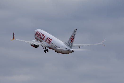 A Malta Air airplane is taking off against a cloudy backdrop, showcasing air travel.